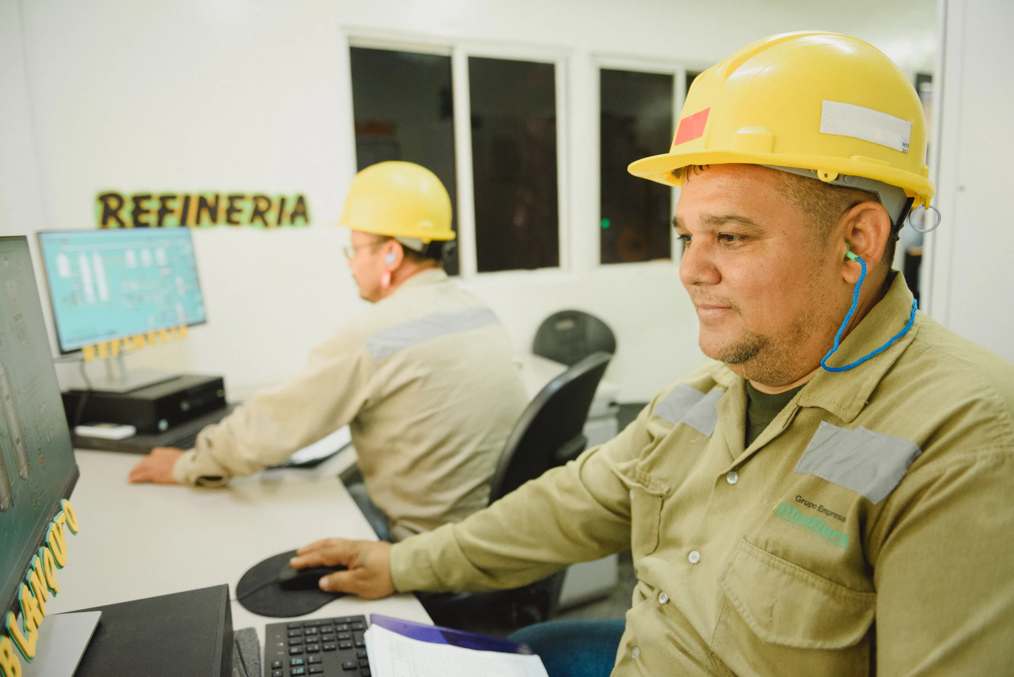 Técnicos supervisando el proceso desde la sala de control de la refinería.